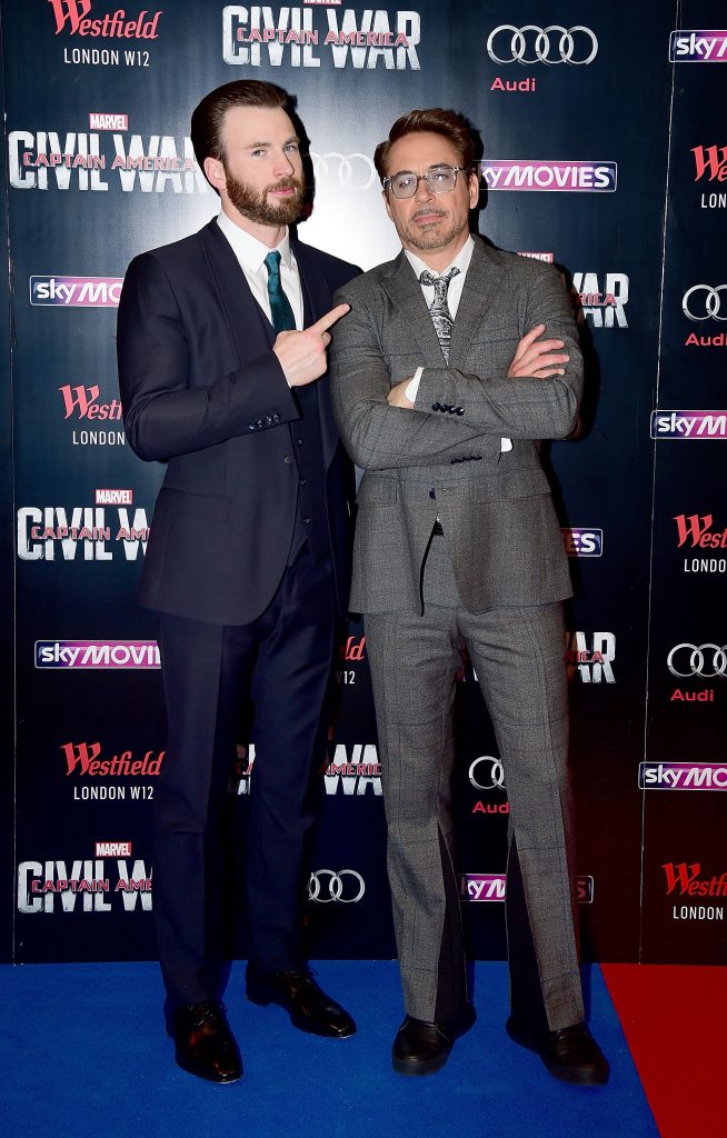 Chris Evans and Robert Downey Jr. on a blue and red carpet for a movie premiere in Europe