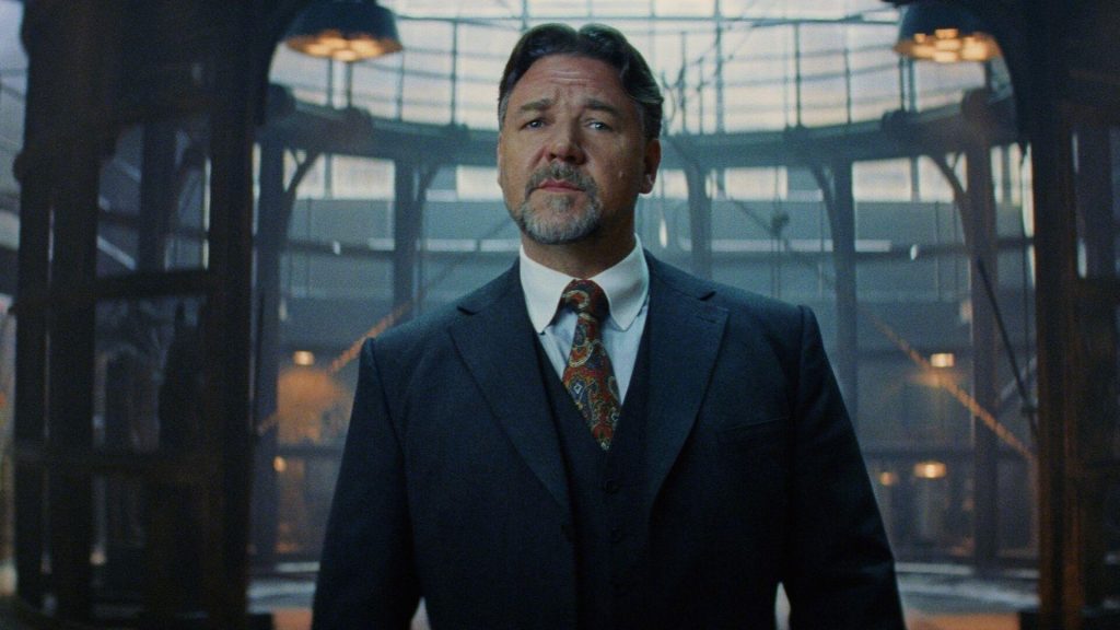 Russell Crowe in a dark suit and red designed tie in the movie Unhinged. 