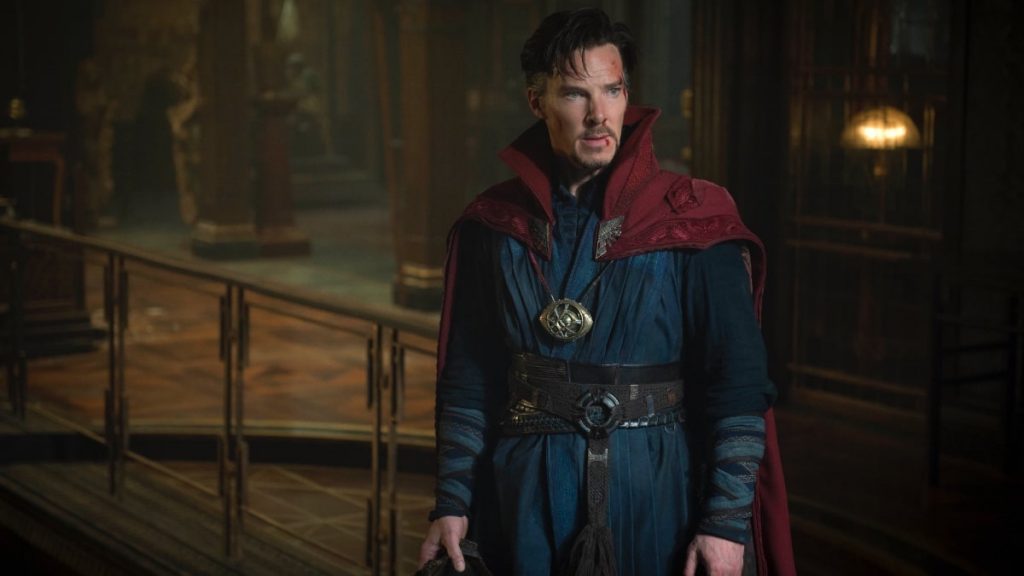Doctor Strange in a blue and red outfit with a small wound on his face